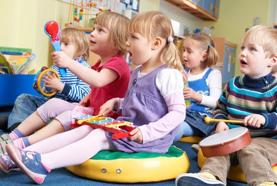 Group Of Pre School Children Taking Part In Music Lesson